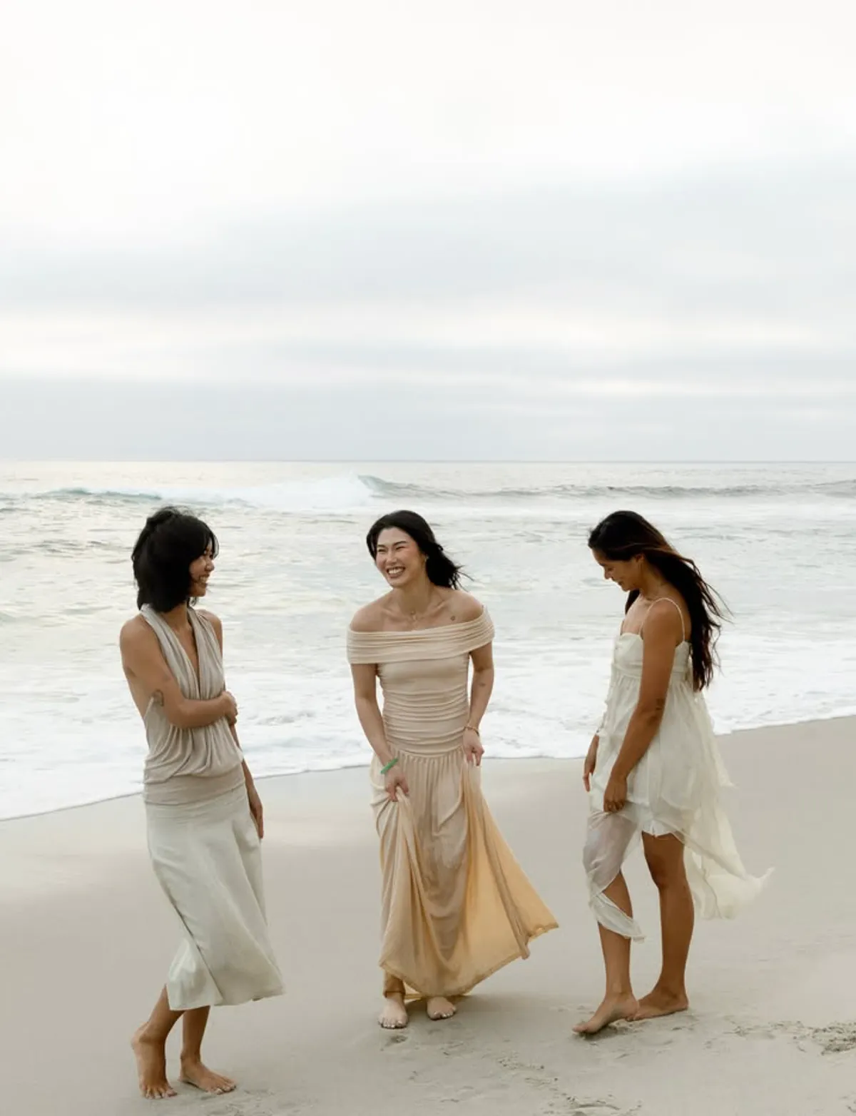 Three friends laughing at the water’s edge, monthly content for a San Diego brand